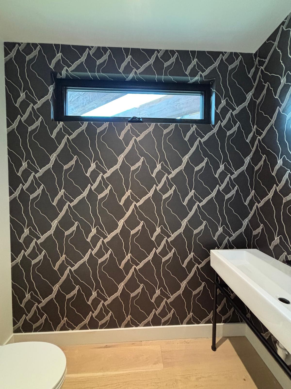 Black and gold geometric wallpaper in a bathroom