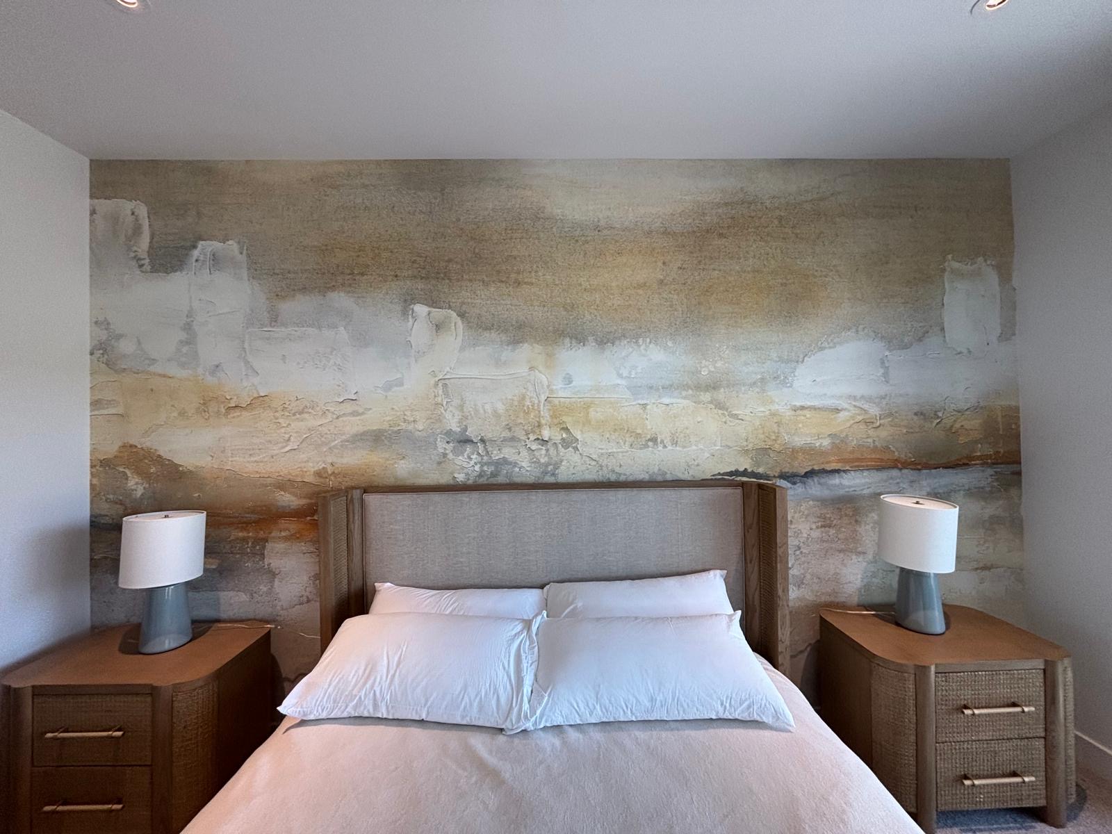 Textured mural wallpaper behind a bed